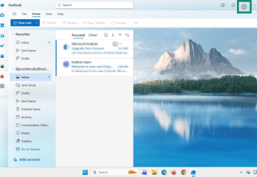 Gear icon highlighted in the top-right corner of the Outlook app on Windows 11.